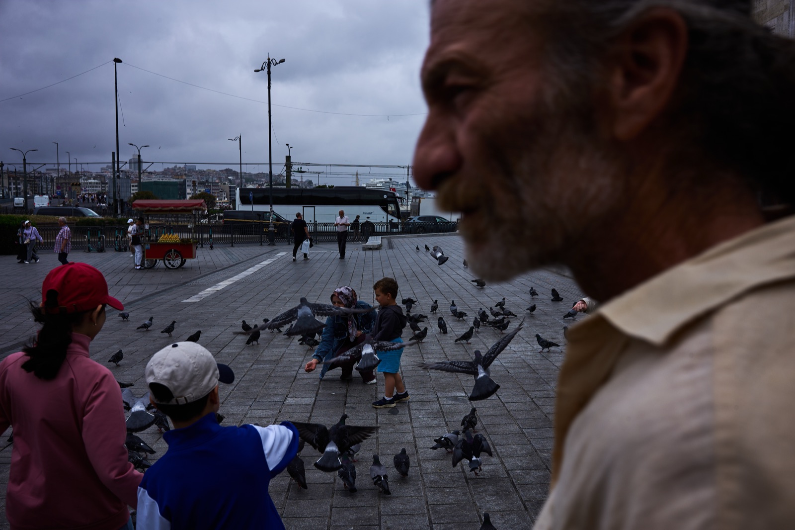Feeding pigeons in Eminonu square under a grey sky