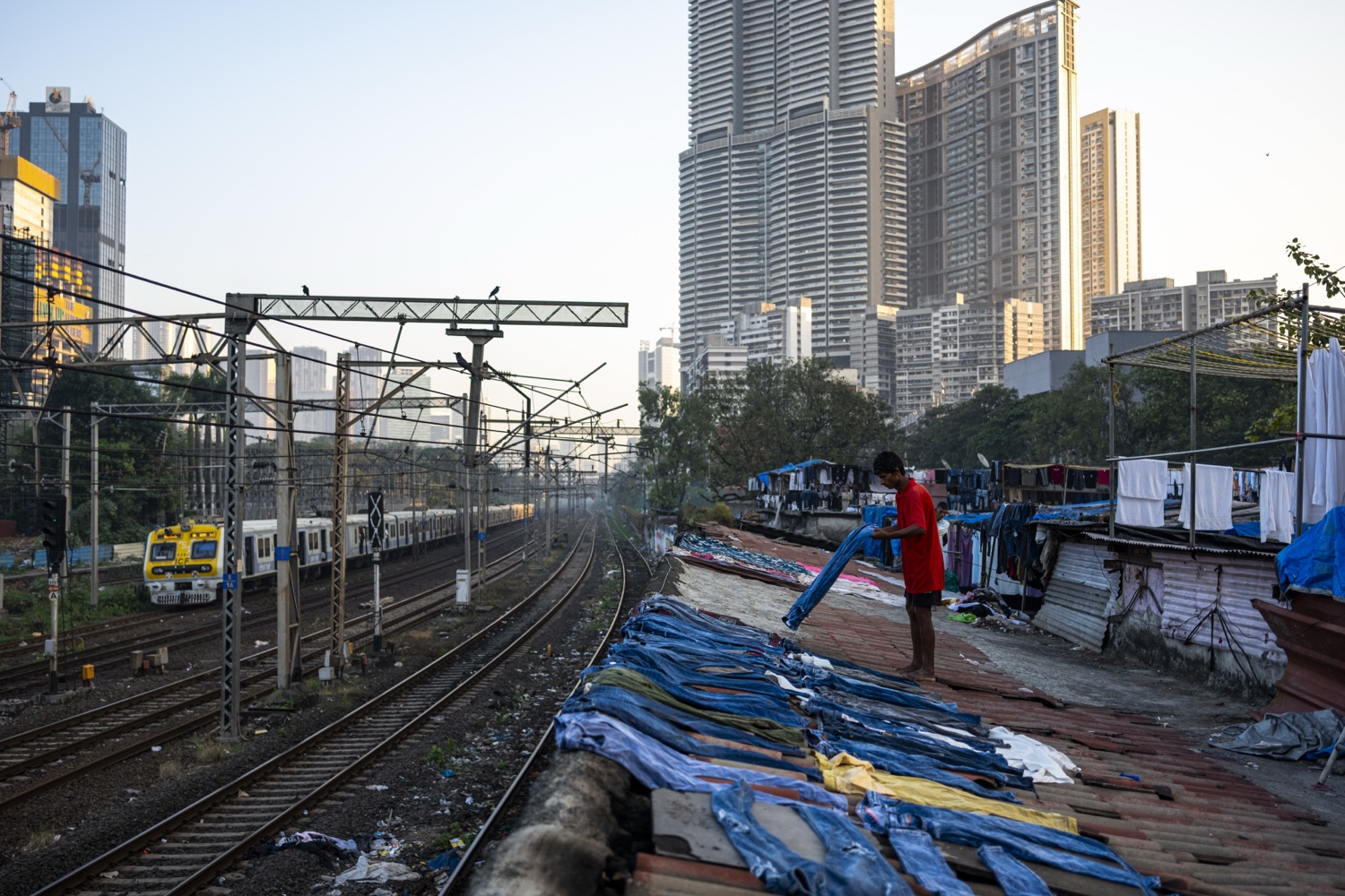 Laundry drying beside the railway tracks against the Mumbai skyline