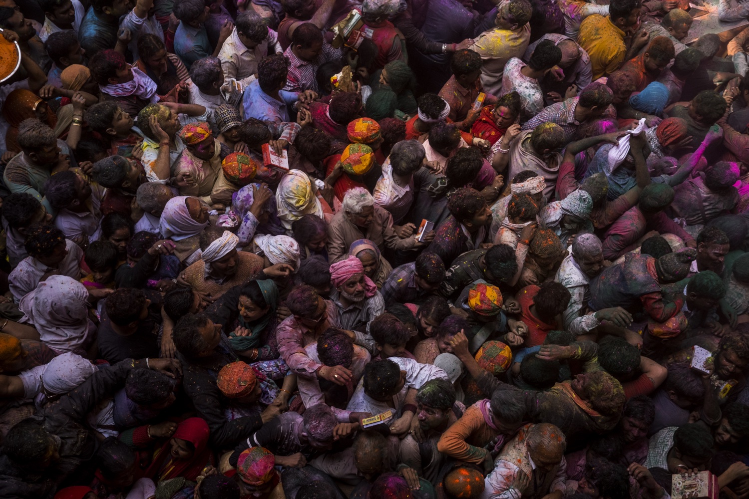 Crowd covered in colour inside a Vrindavan temple during Holi