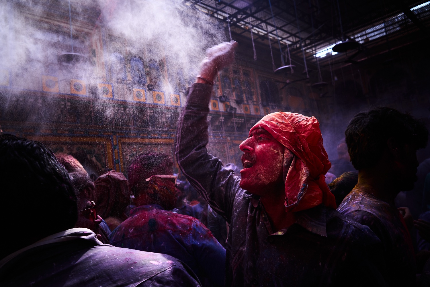 Man throwing colour powder inside a temple during Holi